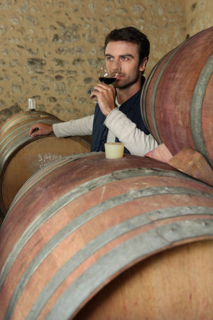 Man tasting wine in a cellar