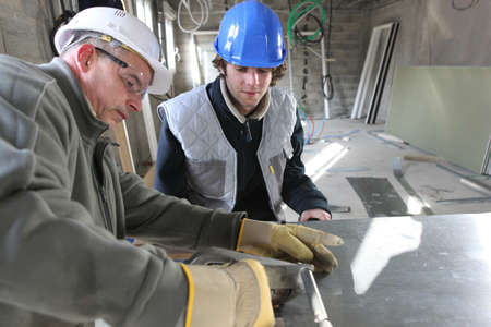 Zinc worker and apprentice in workshop Zinc worker and apprentice in workshop