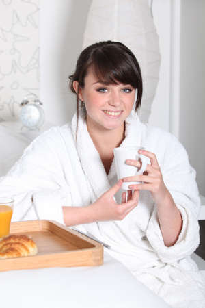 Girl having breakfast in bedの写真素材