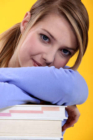 Young woman with a pile of booksの写真素材