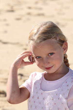 Girl with shell to earの写真素材