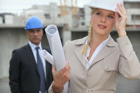 Female architect on site holding her hard hatの写真素材