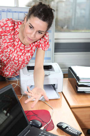 Young woman leaning on a deskの写真素材
