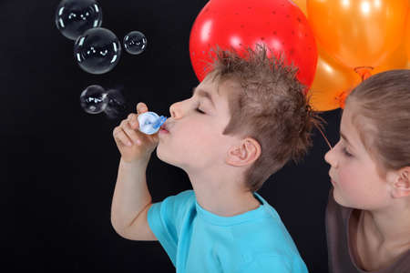 kids making soap bubblesの写真素材