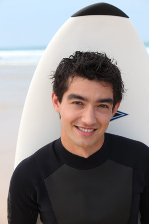 Young male surfer with his board