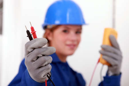 A female electrician holding a voltmeter.の写真素材