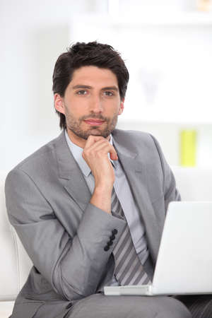 Handsome executive using a laptop computerの写真素材
