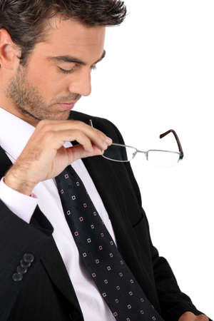 Businessman taking off his glassesの写真素材