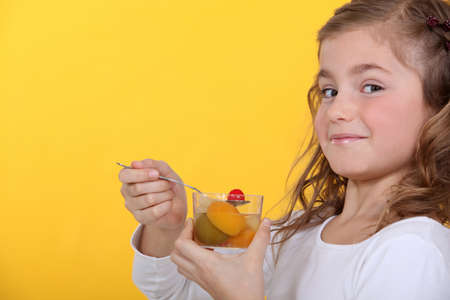 little girl eating a fruit saladの写真素材