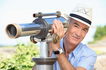 Senior looking through a telescopeの写真素材