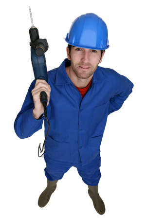 Tradesman holding up an electric screwdriverの写真素材