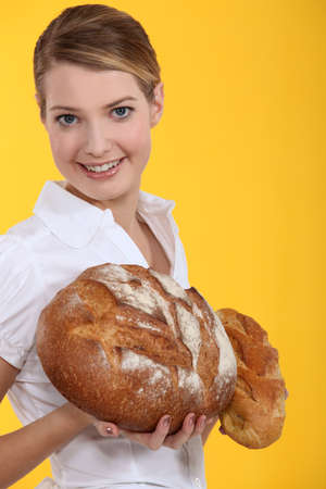 Woman holding round loaves of breadの写真素材