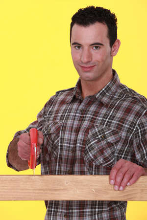 Man sawing a wooden plankの写真素材