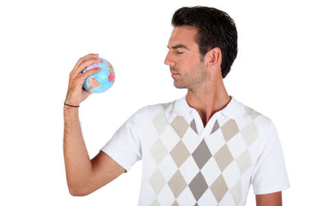 Young man holding a globeの写真素材