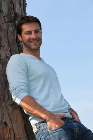 Man leaning against a treeの写真素材