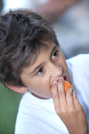 Little boy with apricotの写真素材