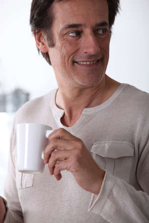 Man smiling with a cup of tea.の写真素材