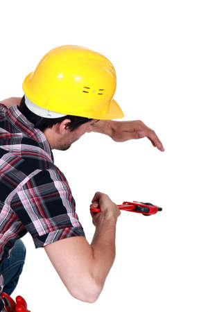 A plumber tightening a pipe.の写真素材