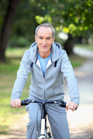mature man doing bike in the forestの写真素材
