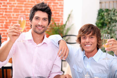 Men drinking champagne in a barの写真素材