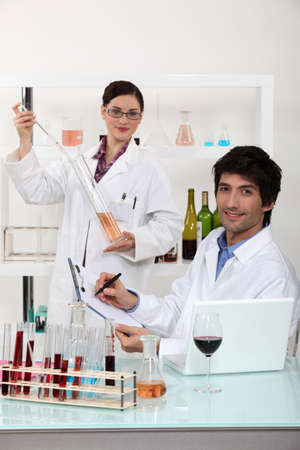 Man and woman testing wine in laboratoryの写真素材