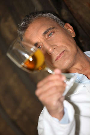 Winemaker examining a glass of wineの写真素材