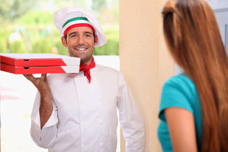 Italian chef bringing pizzasの写真素材
