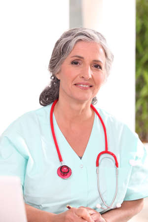 Medic in scrubs working at a deskの写真素材