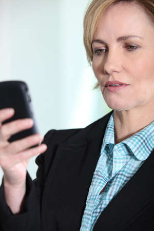 Female executive with mobile phoneの写真素材