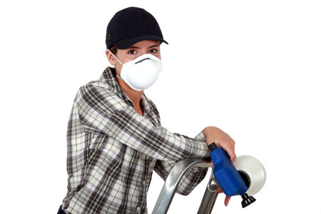 craftswoman on a ladder holding a sprayer