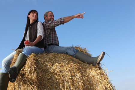portrait of a couple on a hay baleの写真素材