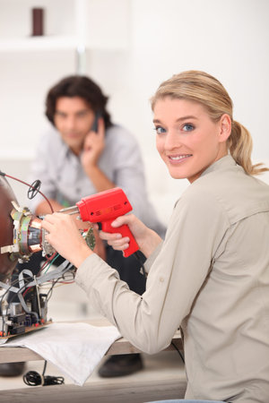 A woman fixing a TV.