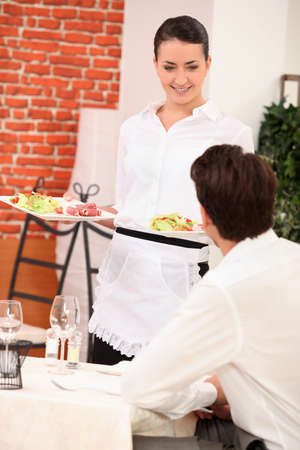 waitress bringing two platesの写真素材