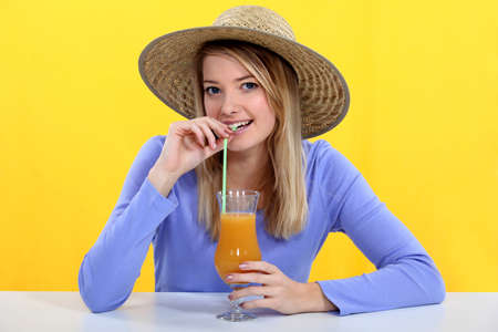 woman drinking fresh juice with a strawの写真素材