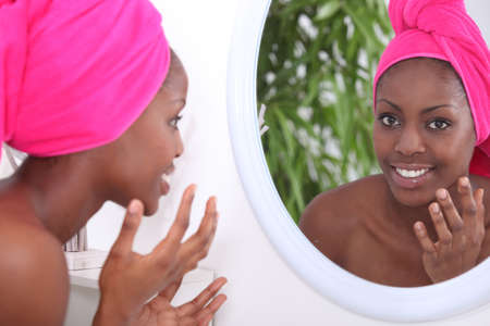 Woman looking in mirrorの写真素材