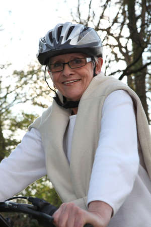 Smiling senior woman on a bikeの写真素材