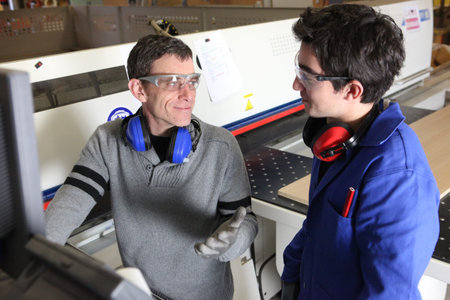 craftsman and apprentice working together at a factory