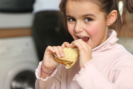 Little girl eating pancakeの写真素材