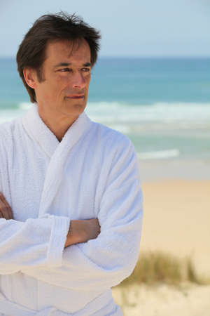 Man standing with arms crossed in the sand dunesの写真素材