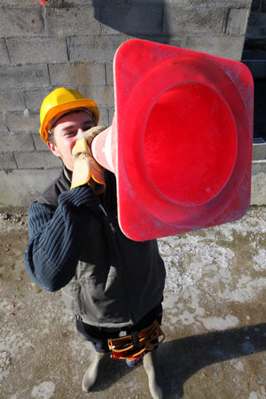 Builder shouting through traffic cone
