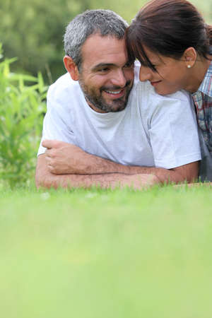 Couple laying in fieldの写真素材