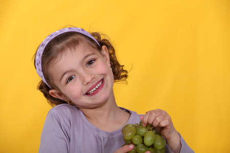 Young girl with a bunch of grapesの写真素材