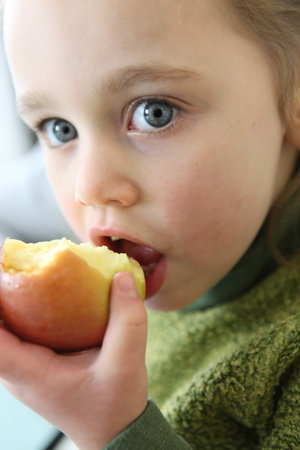Little girl eating apple