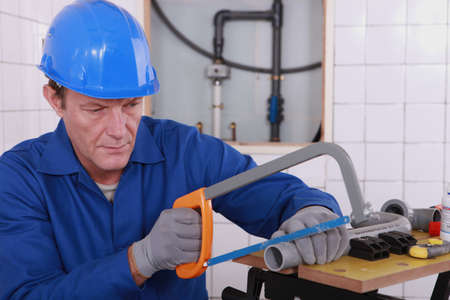 Plumber sawing plastic pipeの写真素材