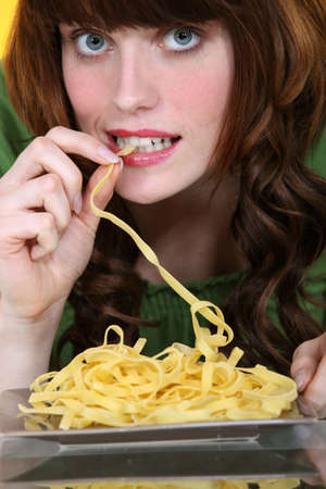woman eating pastaの写真素材