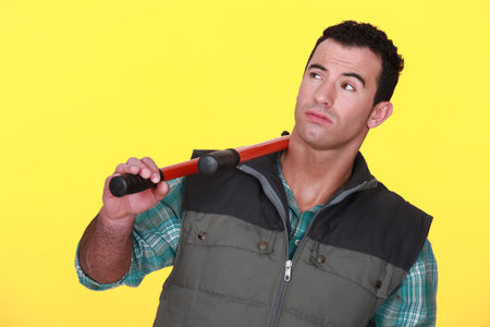 Man resting bolt cutters over shoulder