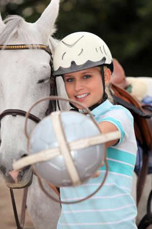 Blond teenager stood next to horseの写真素材