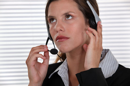Brunette call-center worker adjusting head-set