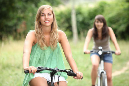 Two teenage girls cyclingの写真素材