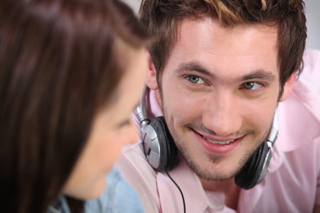 young man and woman listening music at homeの写真素材